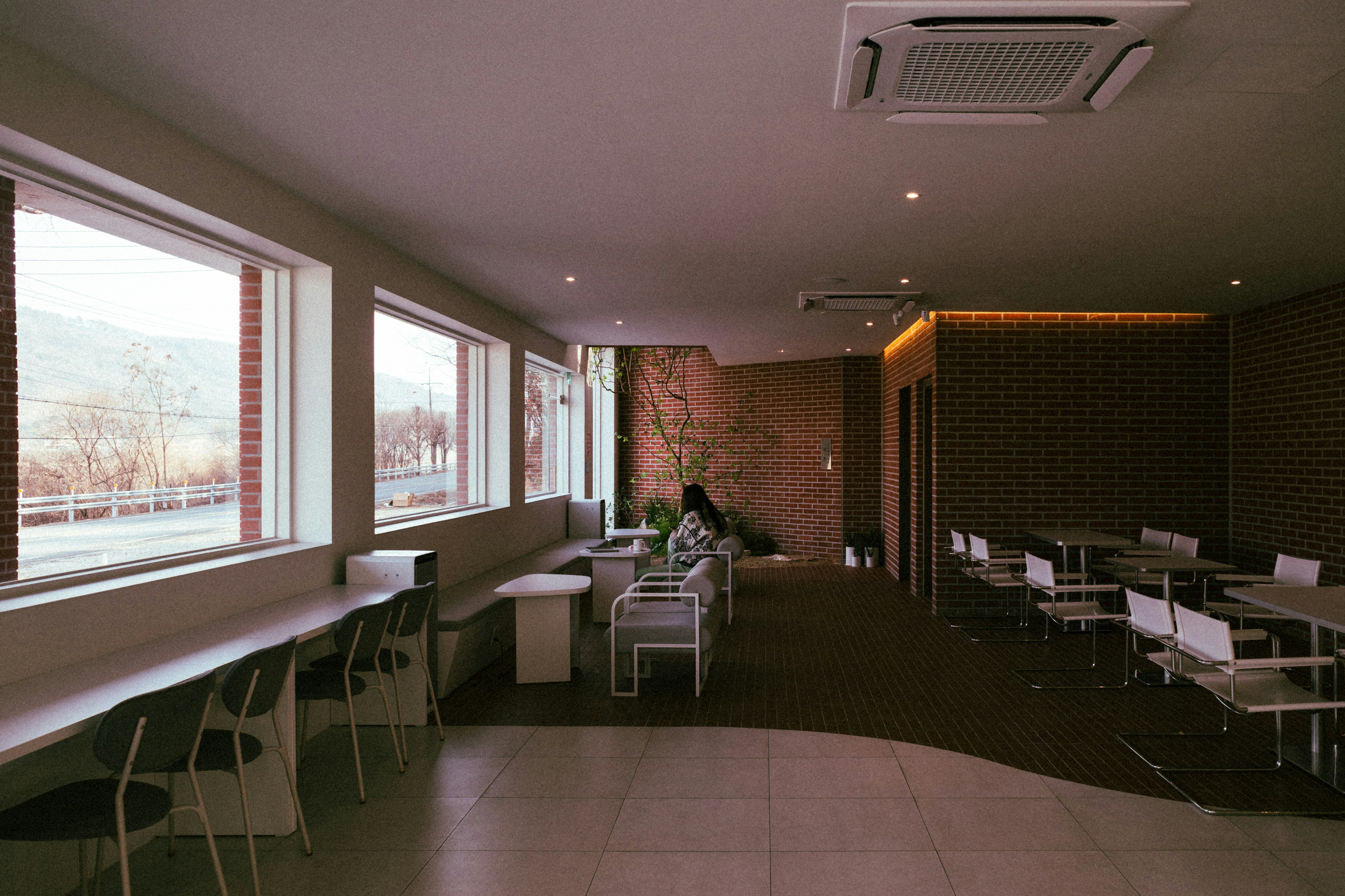 a room with tables and chairs and a brick wall