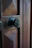 Close-up of a bronze door knob on a wooden farmhouse door with soft natural light.