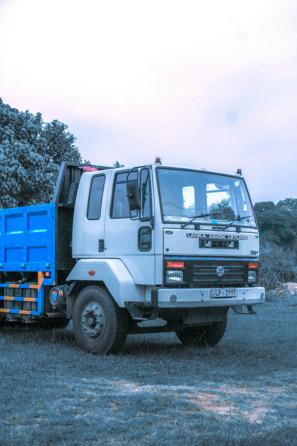 a white and blue truck parked in a field