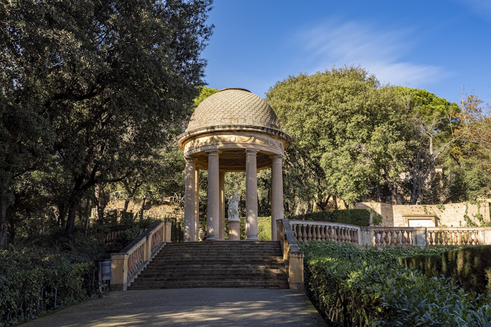 a gazebo in the middle of a park surrounded by trees