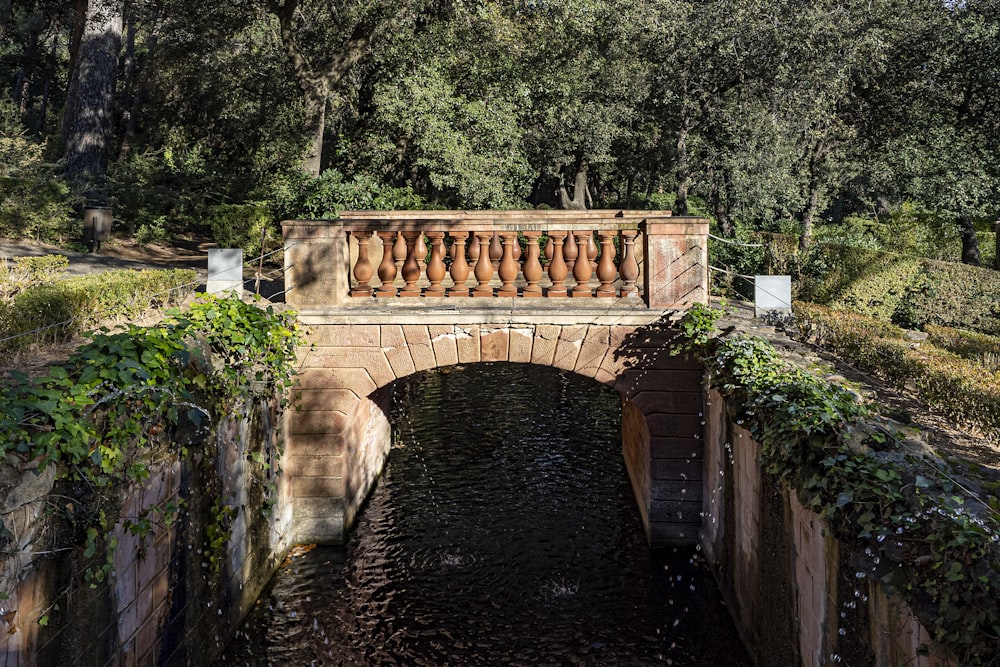 a stone bridge over a small stream in a park