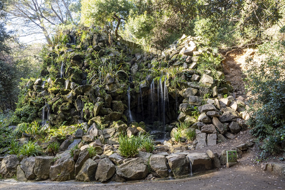 a waterfall surrounded by rocks and trees