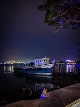 A welcoming Amazonian river scene at sunset with a small wooden boat tied to a dock near lush vegetation.