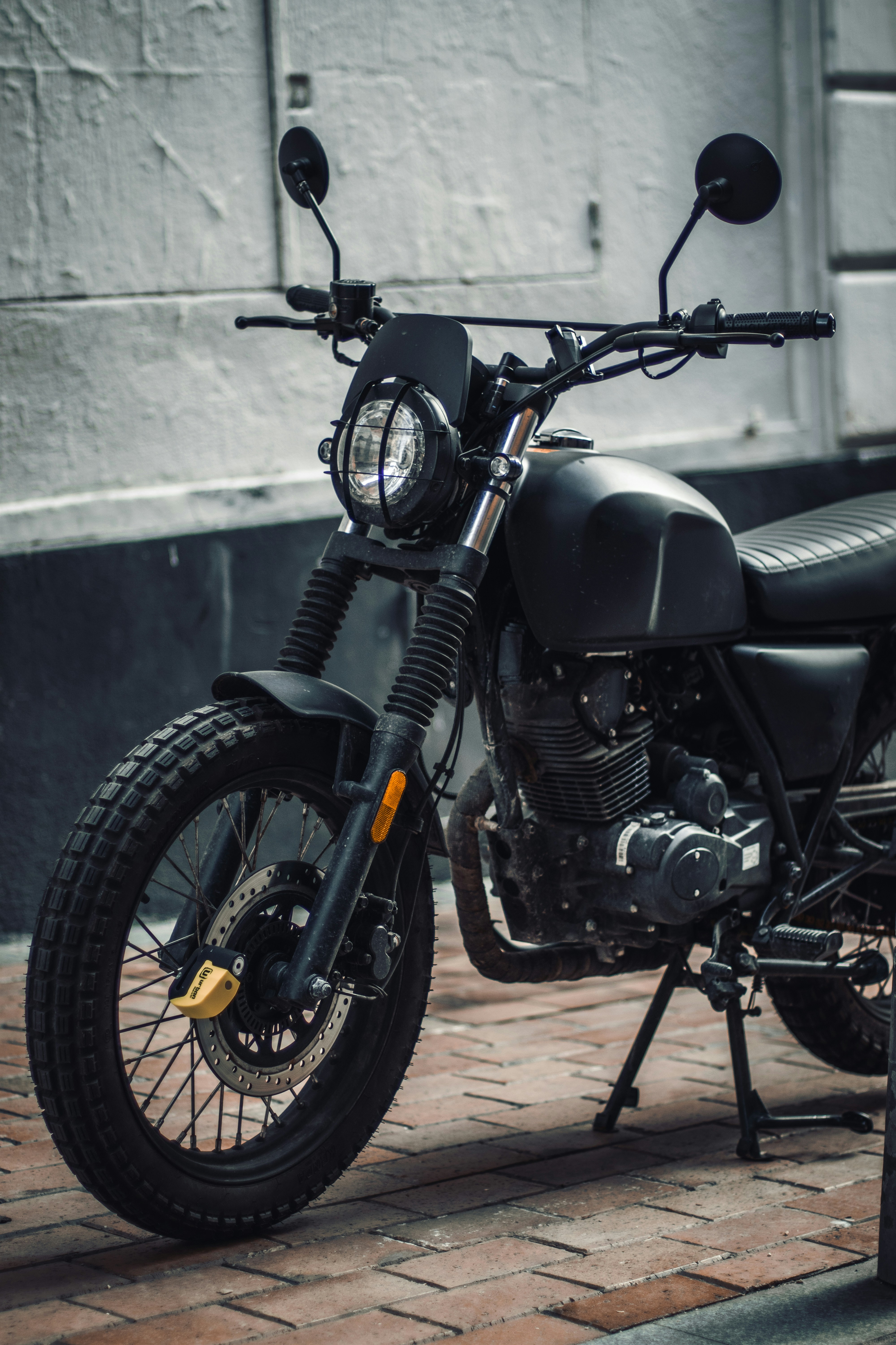 Ein schwarzes Motorrad parkt auf einem gemauerten Bürgersteig