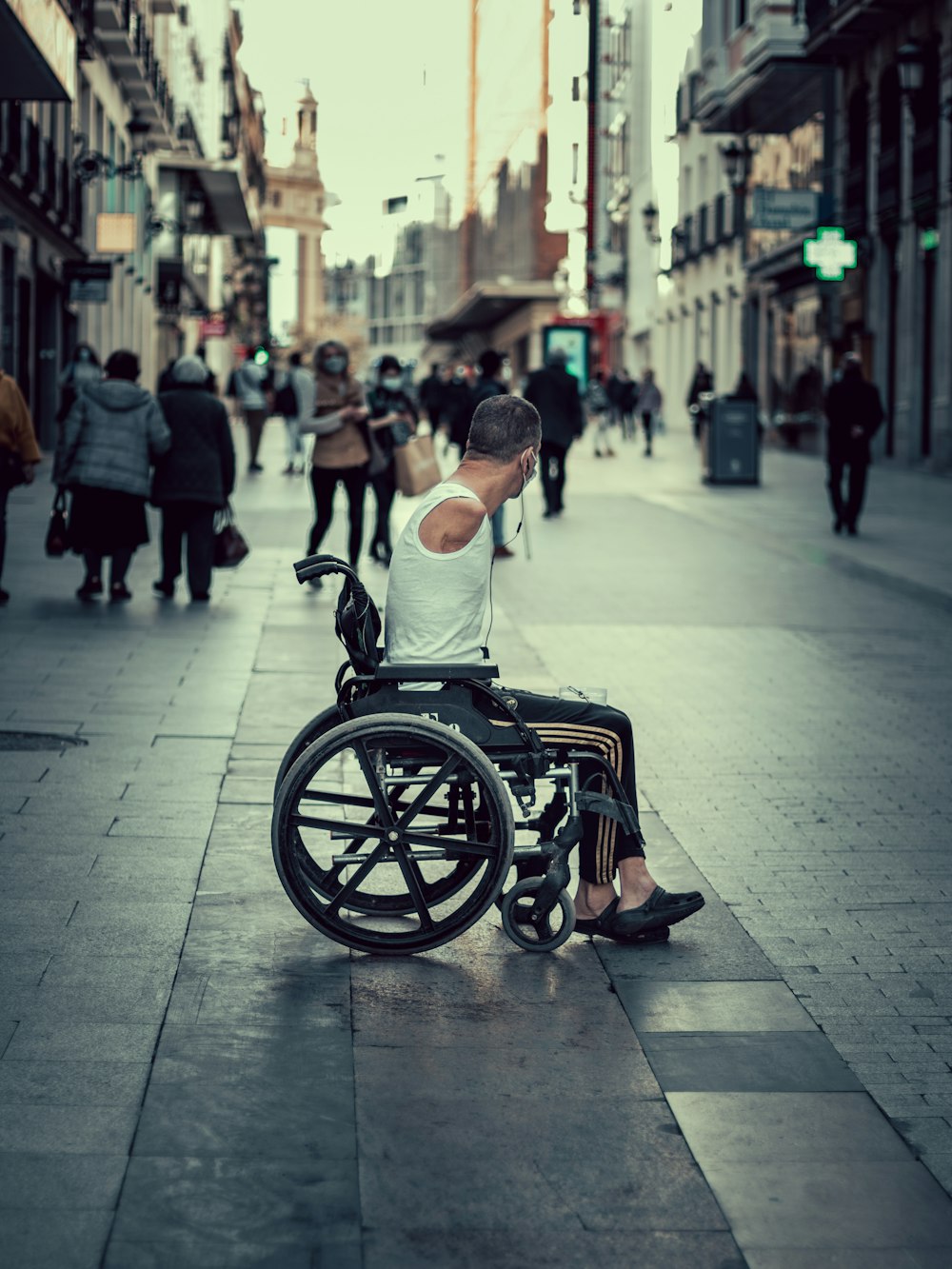 a man in a wheelchair sitting on a sidewalk