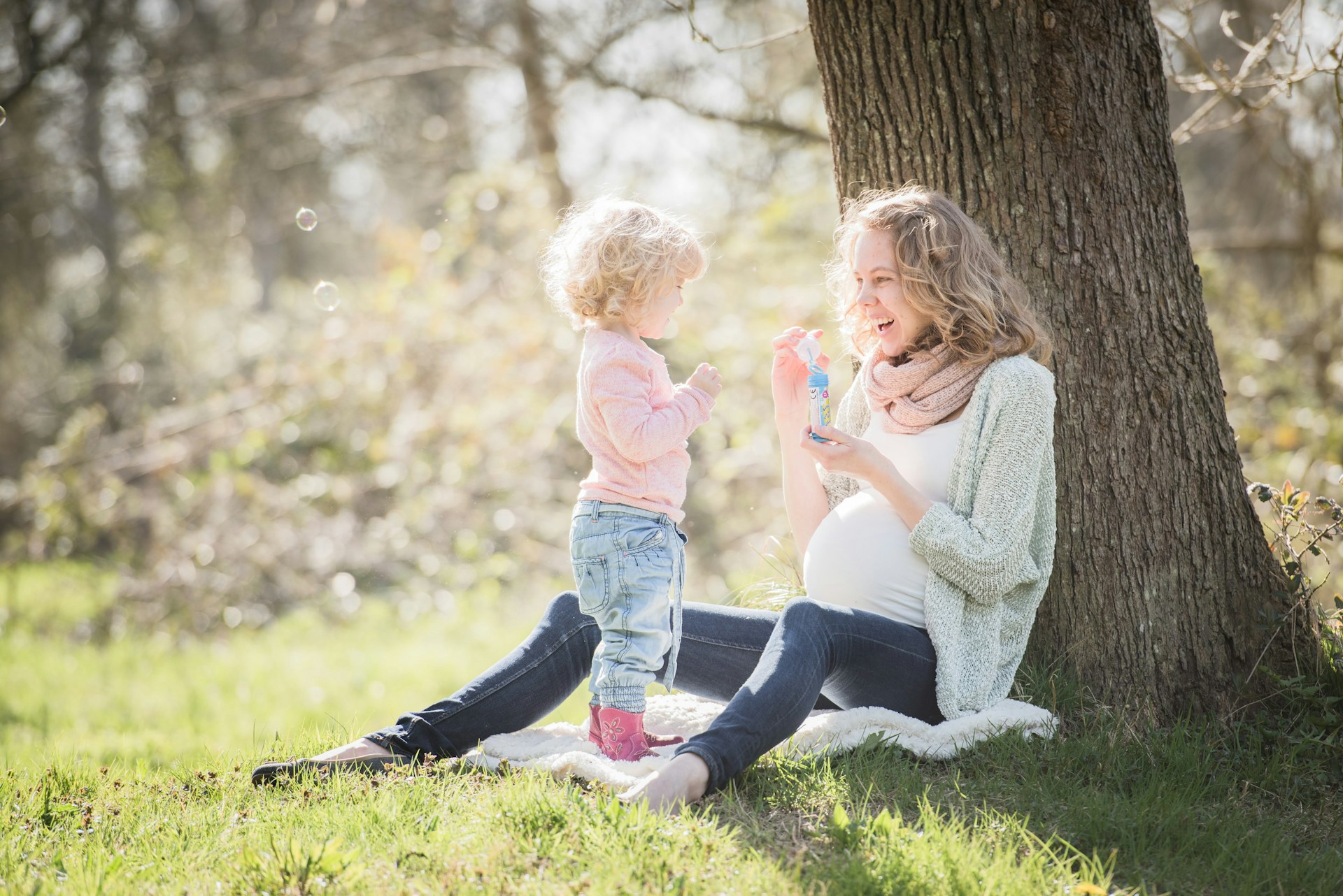 a woman and a child sitting under a tree