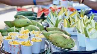 A vibrant display of fresh mangoes and mango fruit bars arranged on a rustic wooden table.