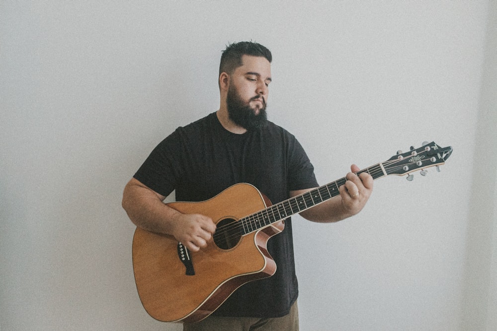 a man with a beard playing a guitar