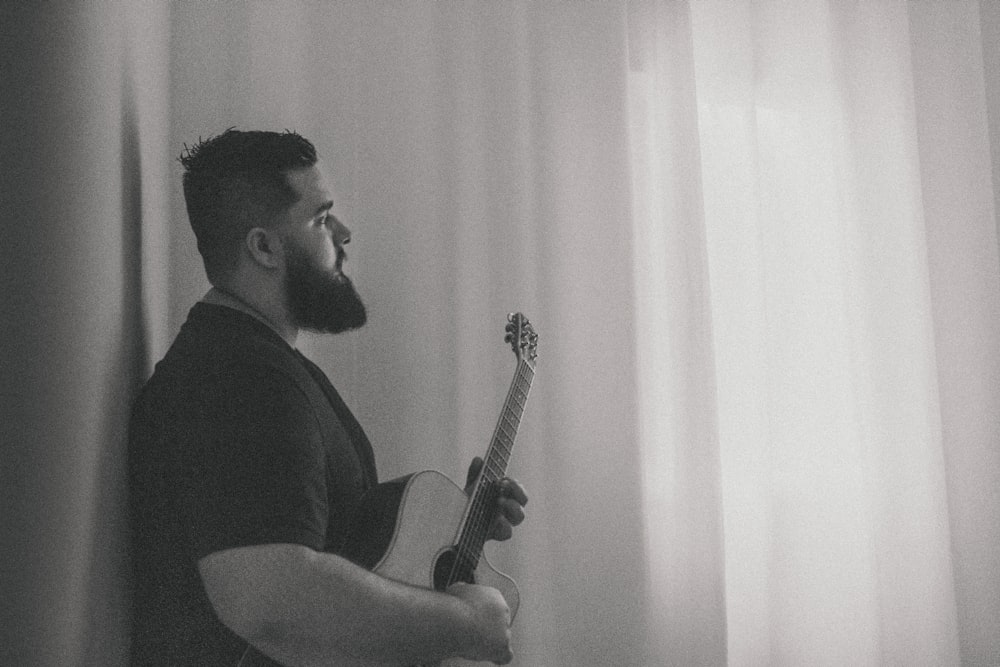 a man with a beard playing a guitar