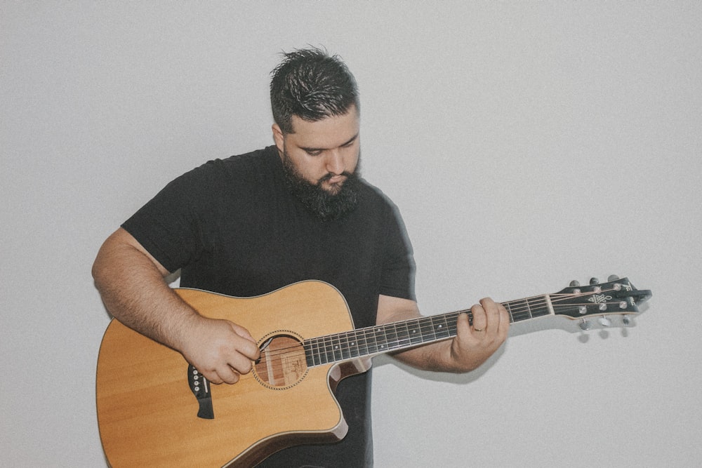 a man with a beard playing a guitar