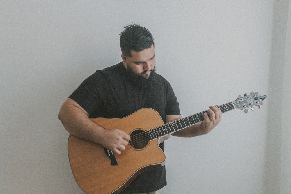 a man with a beard playing a guitar