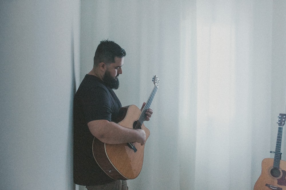 a man playing a guitar in a room