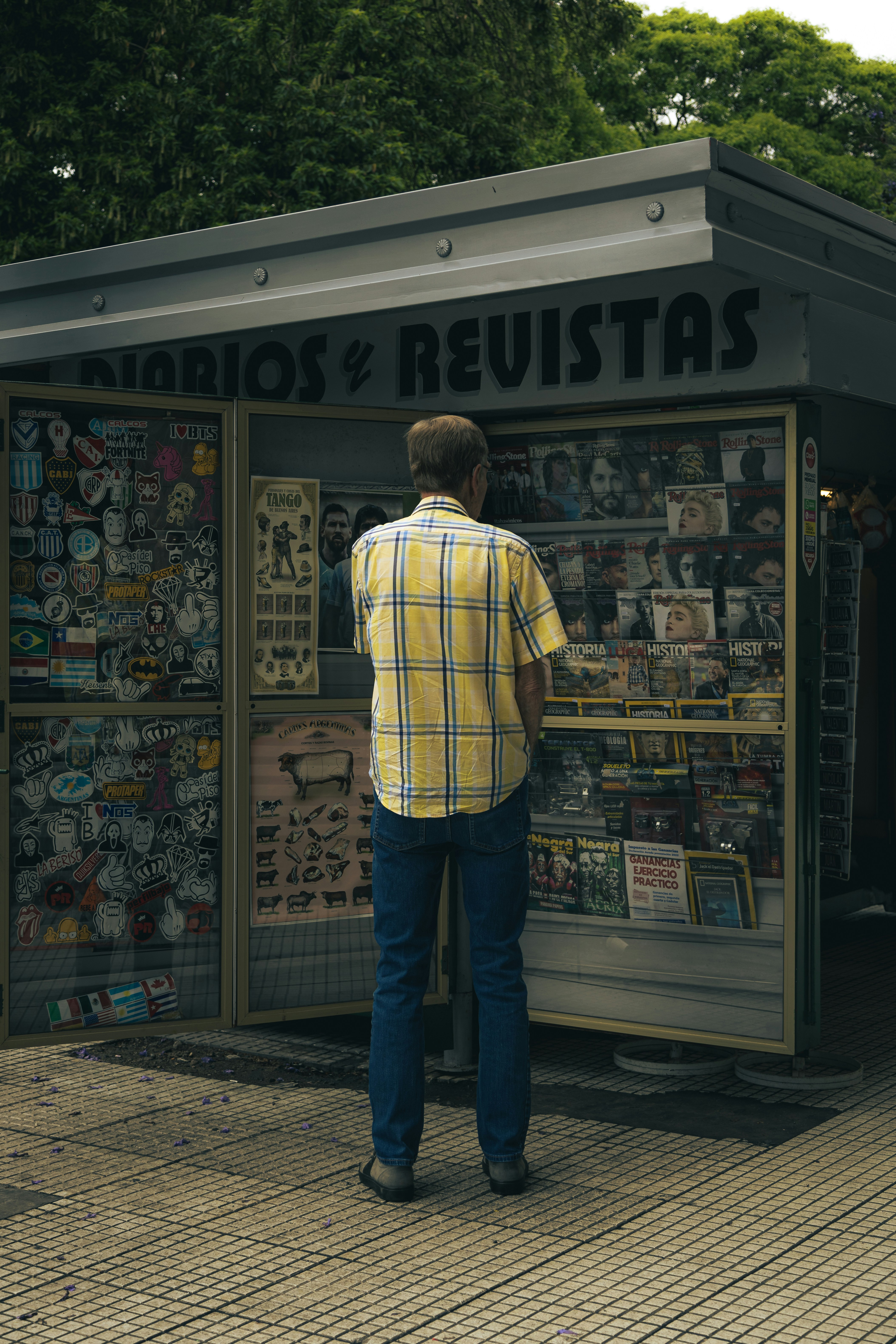 A man standing in front of a newspaper stand photo – Free Man Image on ...