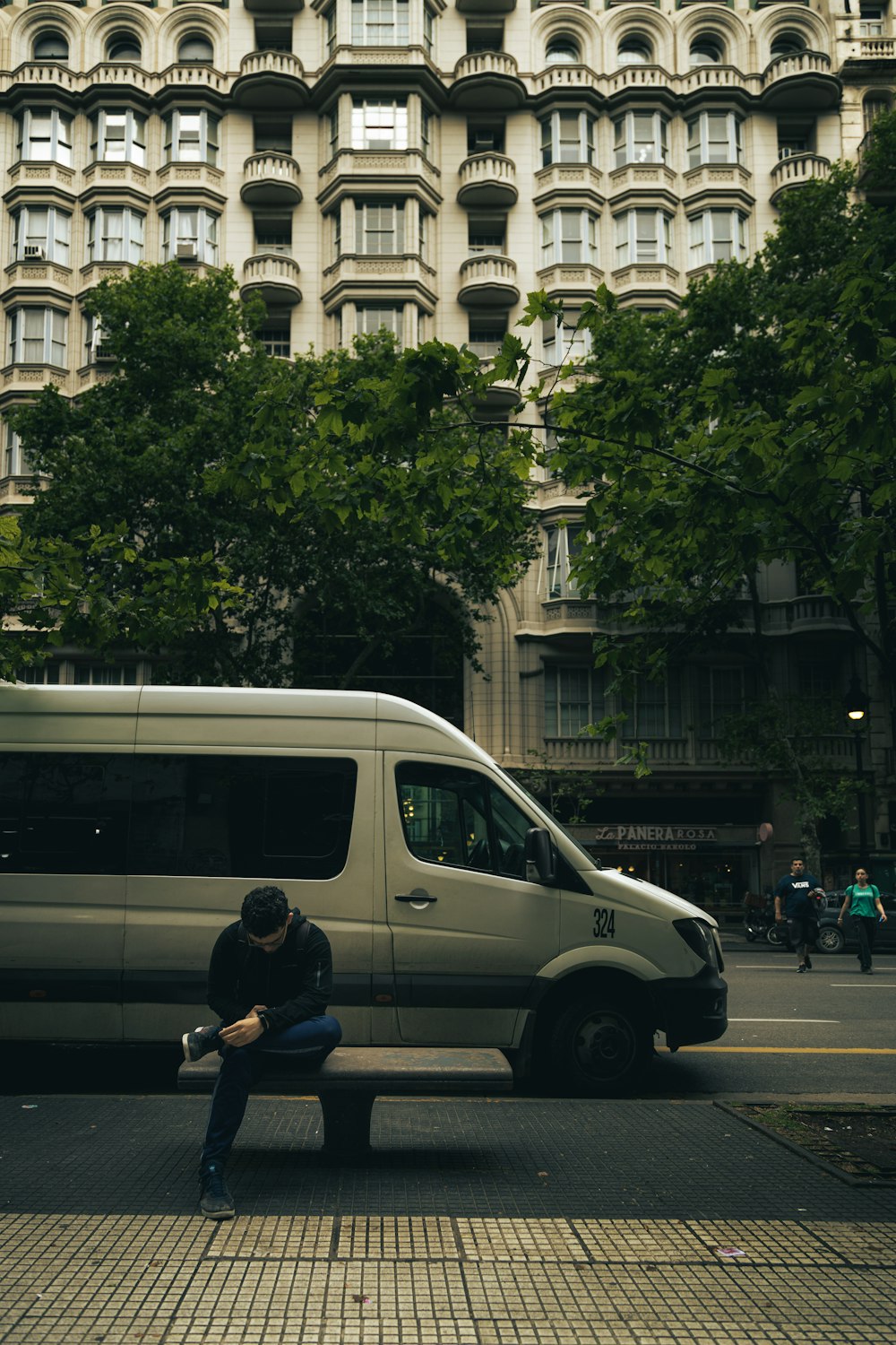 a man sitting on a bench next to a van