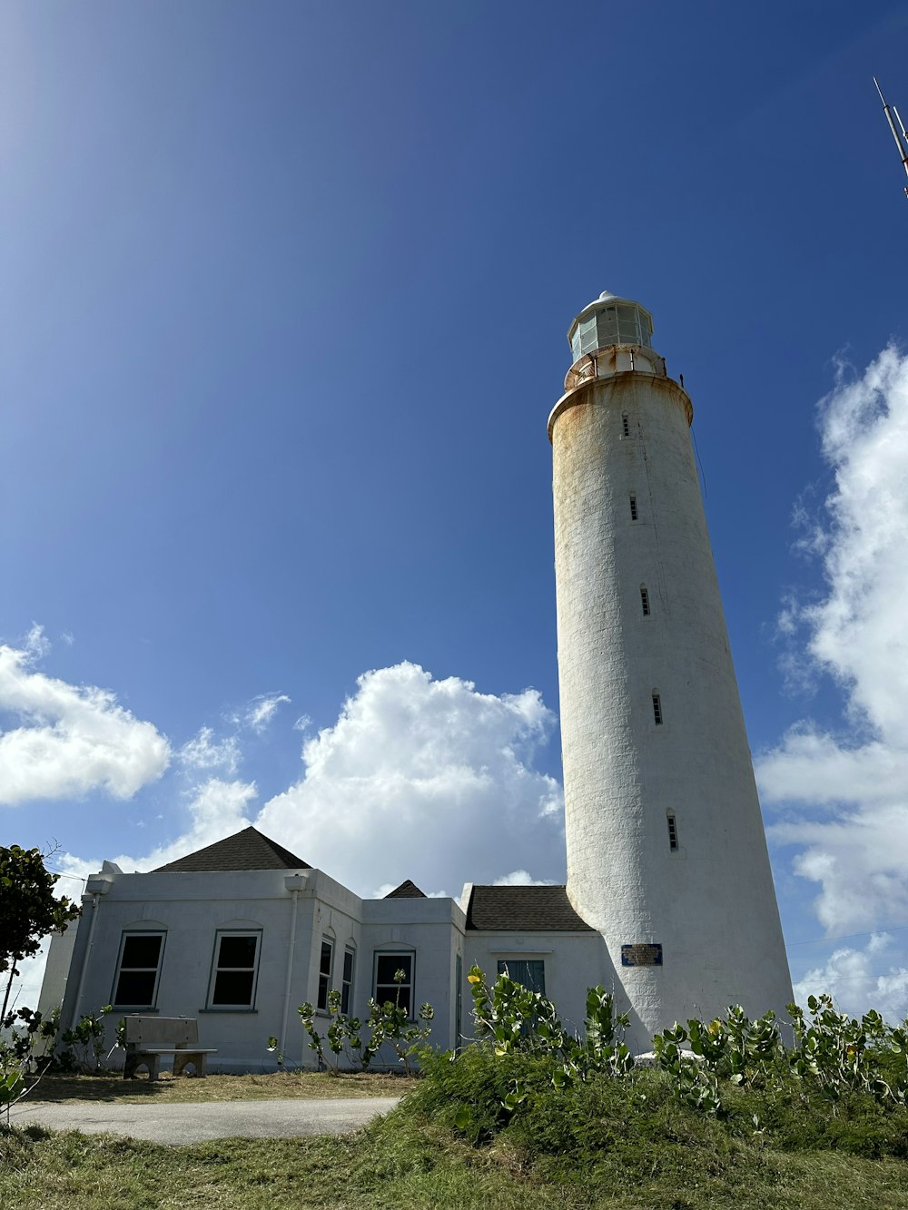 a light house sitting on top of a lush green field