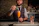 Elegant bartender preparing a signature cocktail at a luxurious private event with golden accents.