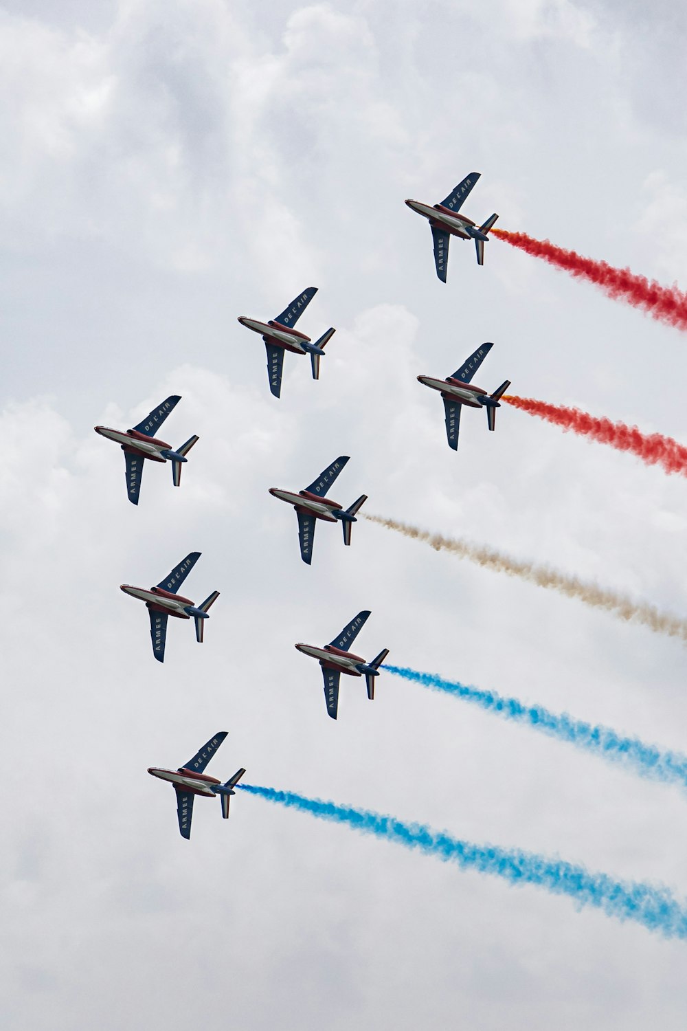 a group of fighter jets flying through a cloudy sky