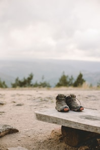 a pair of shoes sitting on top of a wooden bench