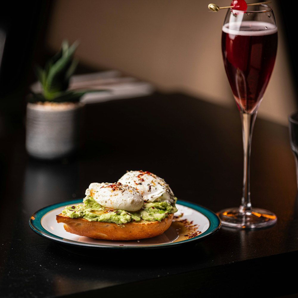 a plate of food and a glass of wine on a table