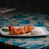 a white plate topped with meat and rice