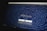 A website homepage displayed on a computer screen featuring a design made up of various letters and symbols, forming an artistic pattern around the central text that reads 'Midjourney'. Below the text, there are navigational options such as 'Join the Beta', 'Sign In', 'Getting Started', and 'Community Showcase'. The background is predominantly dark with white text.
