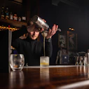 a man pouring a drink at a bar