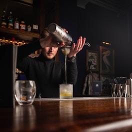 a man pouring a drink at a bar