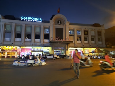 a busy city street at night with a clock tower in the background