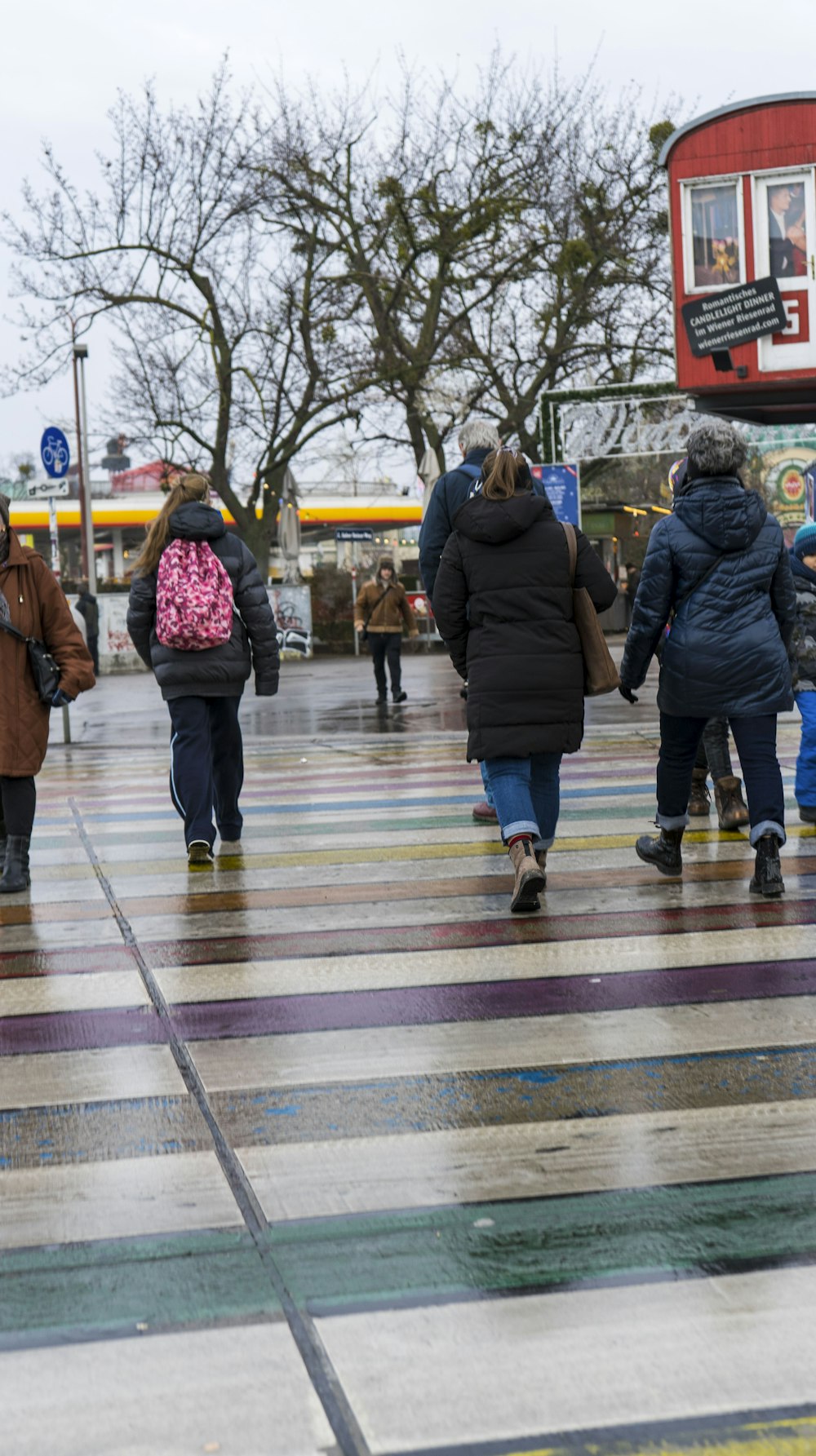 a group of people walking down a street in the rain