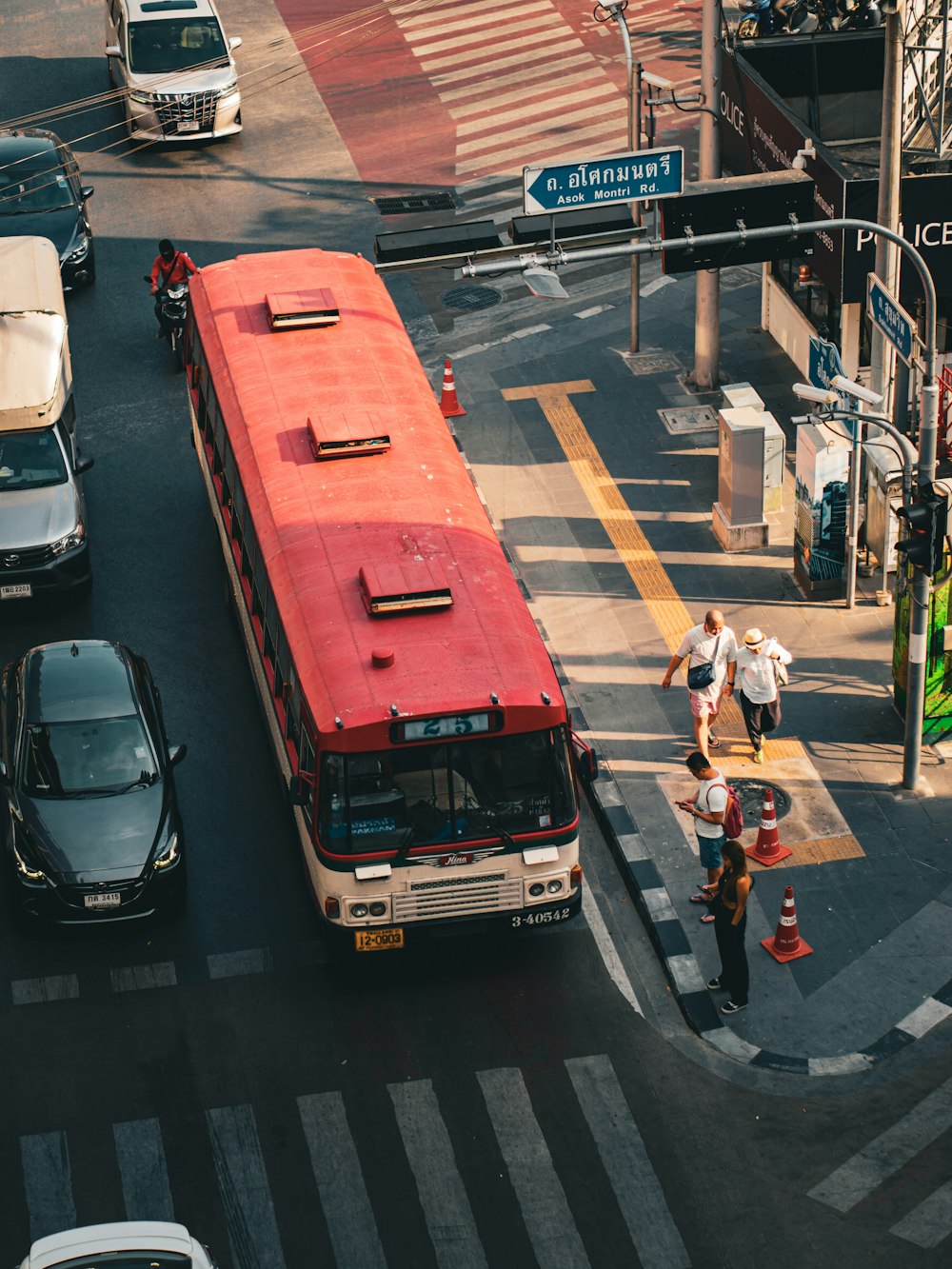 a red and white bus driving down a street