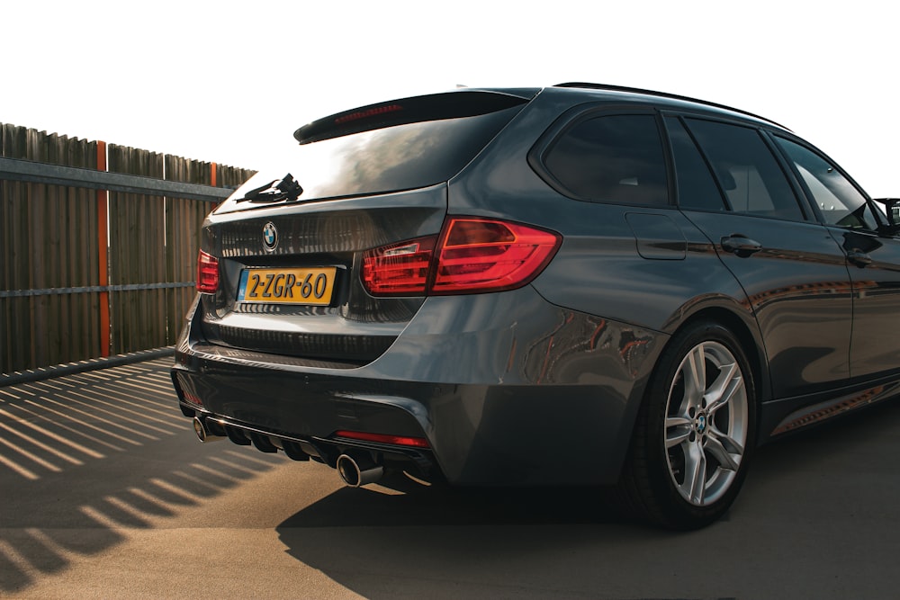 a grey bmw car parked on the side of a road