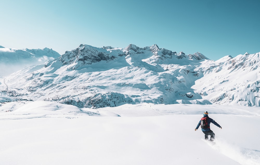 a man riding skis down a snow covered slope