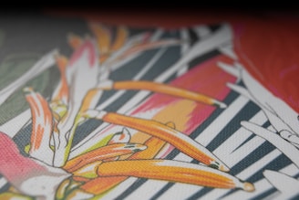 A close-up of a black canvas with shimmering gold paint strokes forming an abstract pattern, framed by an ornate gold frame.