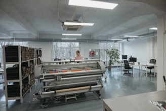 a woman standing in a large room with lots of desks