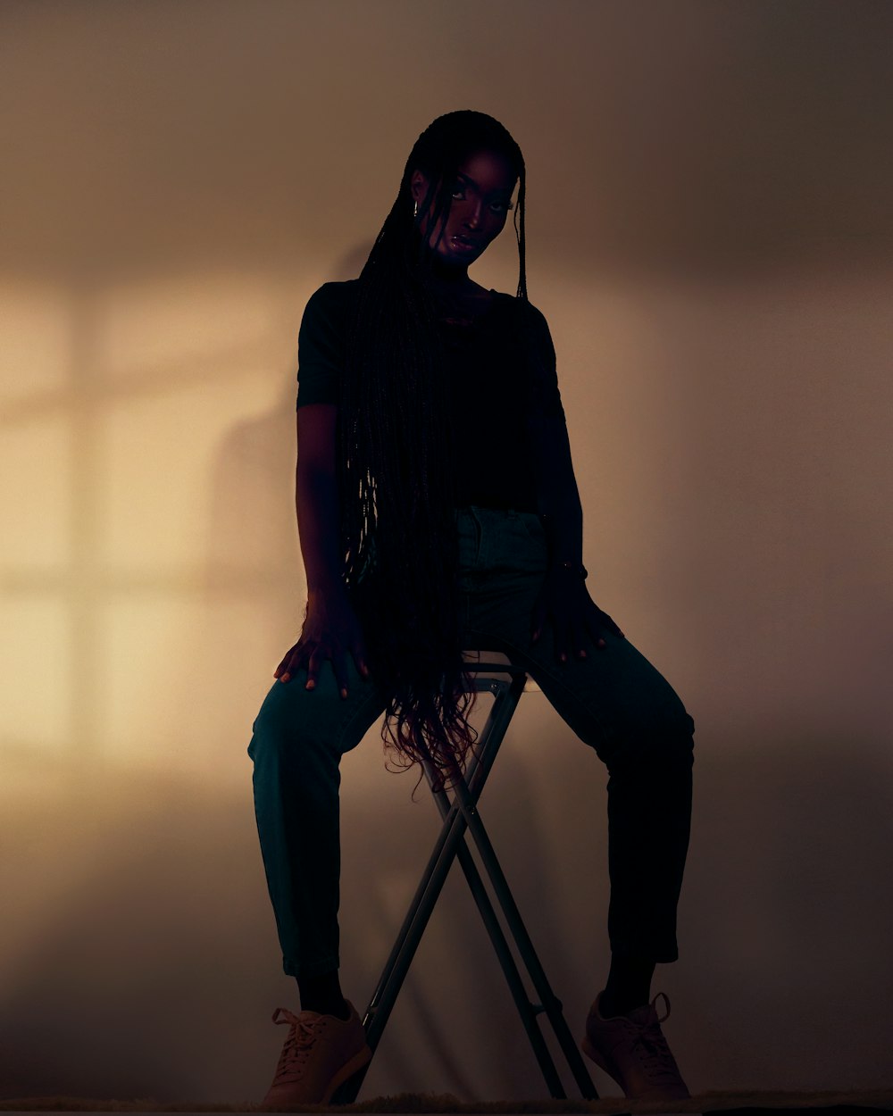 a woman sitting on top of a chair next to a window