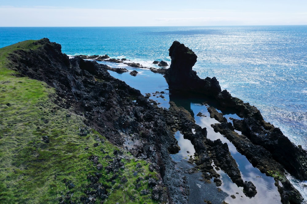 a large body of water sitting next to a lush green hillside