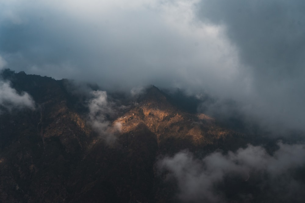 a view of the top of a mountain covered in clouds