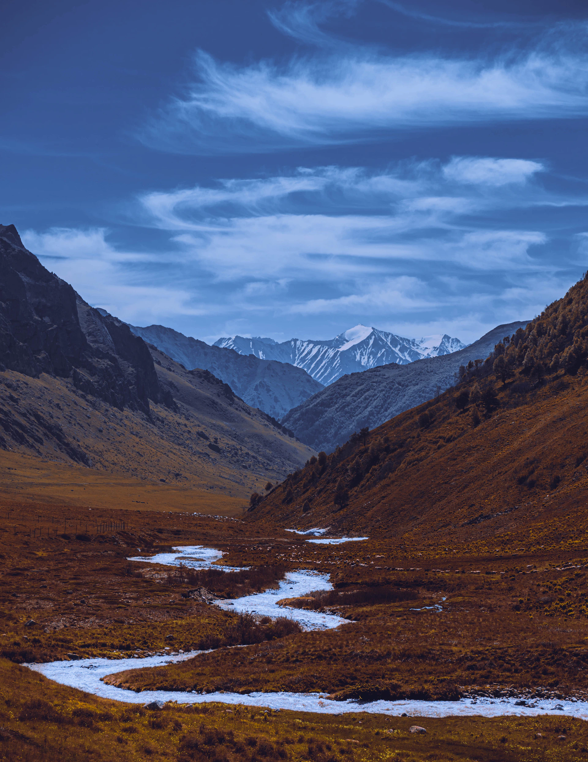 A serene snapshot of Swat Kalam's flowing river with towering mountains in the background, inviting adventurers.