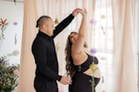 a man and a woman dancing in front of a window