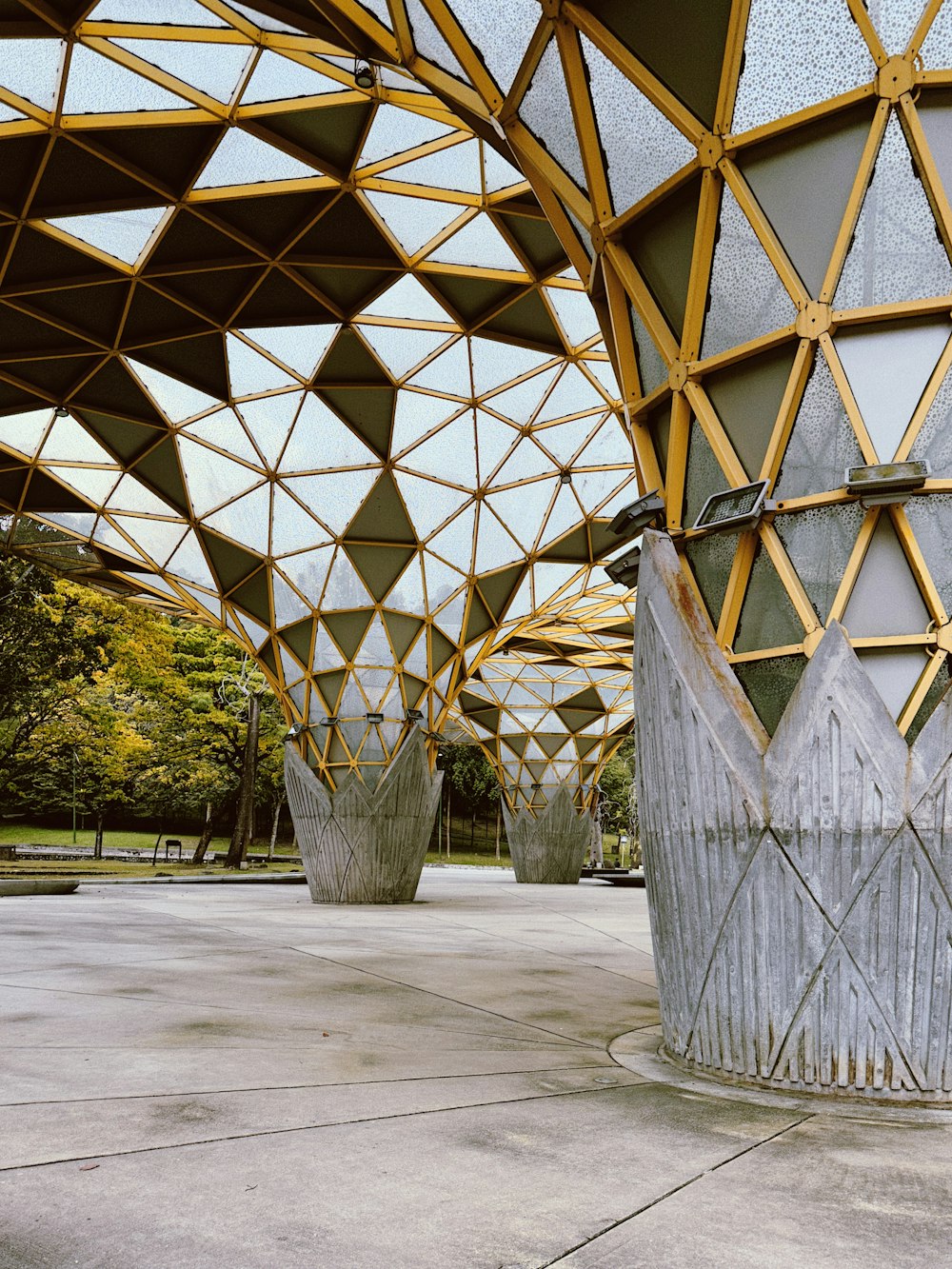 a large metal structure sitting next to a forest
