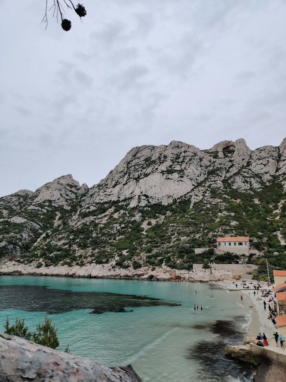 Un gruppo di persone in piedi sulla cima di una spiaggia vicino a una montagna