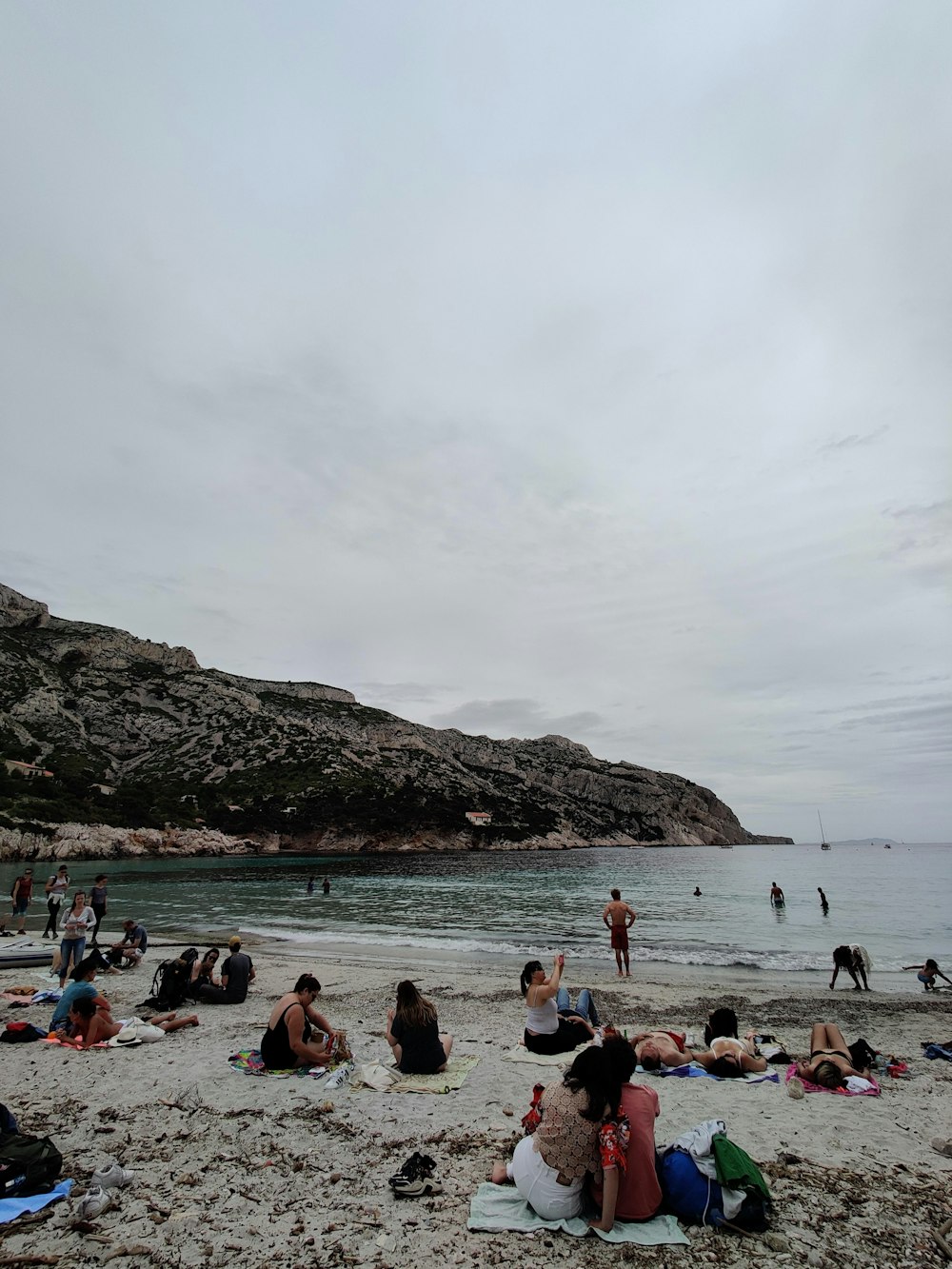 a group of people sitting on top of a sandy beach