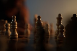 a close up of a chess board with a person in the background