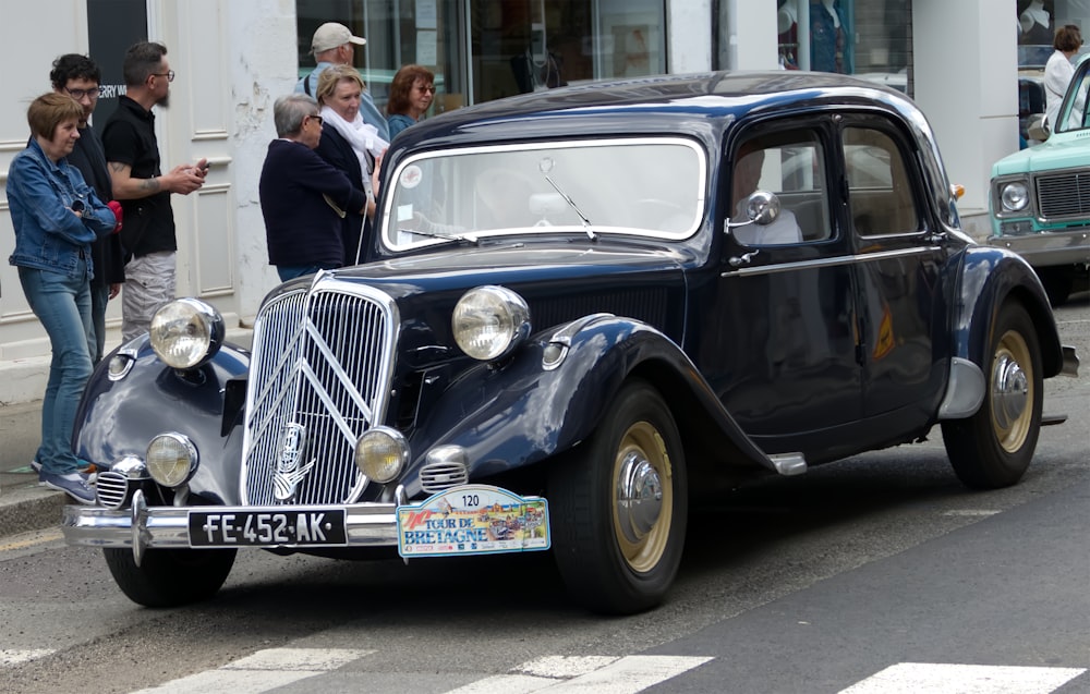 a vintage car is parked on the side of the road