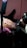 A person is in the process of getting a tattoo on their leg. The tattoo artist is wearing gloves and using a tattoo machine to ink an elaborate design outlined in purple. The setting appears to be indoors with a pink covering on the chair.
