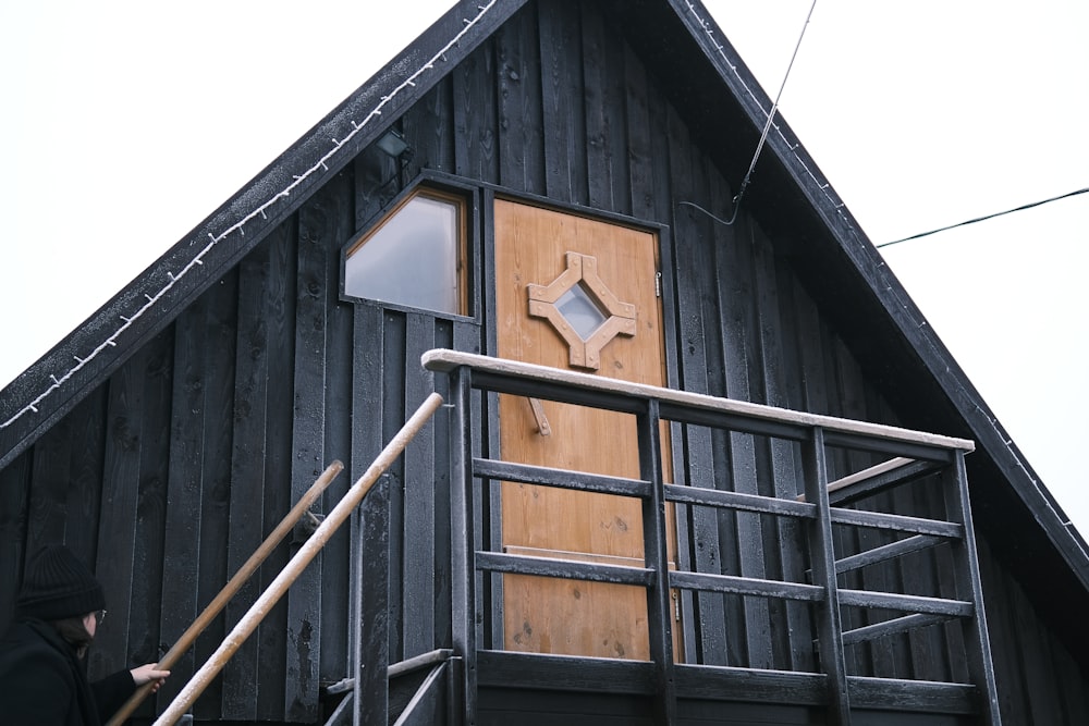 a person standing outside of a wooden building