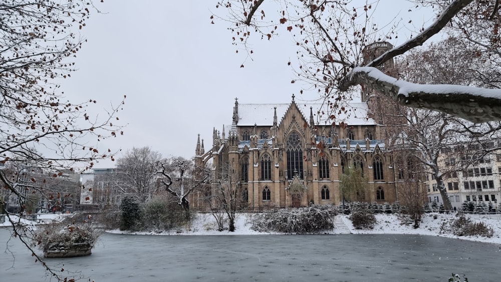 a large building sitting next to a river covered in snow