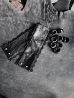 Glossy black leather harness displayed against a moody wine-colored backdrop.