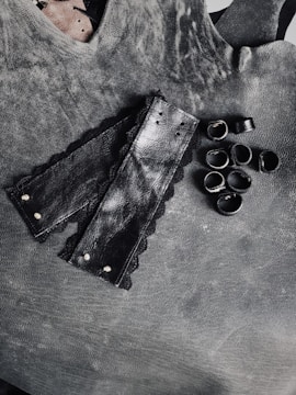 An elegant leather harness with metal accents laid out on a soft fabric background.