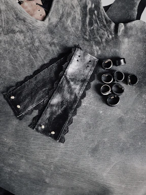 Close-up of elegant leather cuffs with soft padding on a dark velvet background.